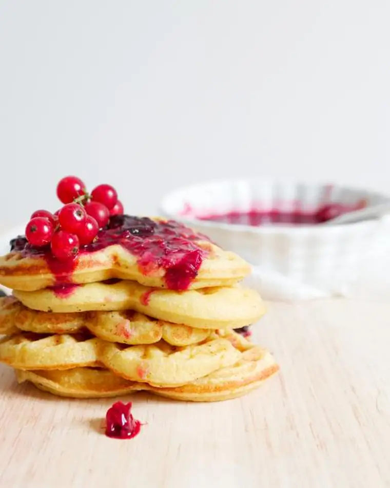 Stack of waffles with berries and jam